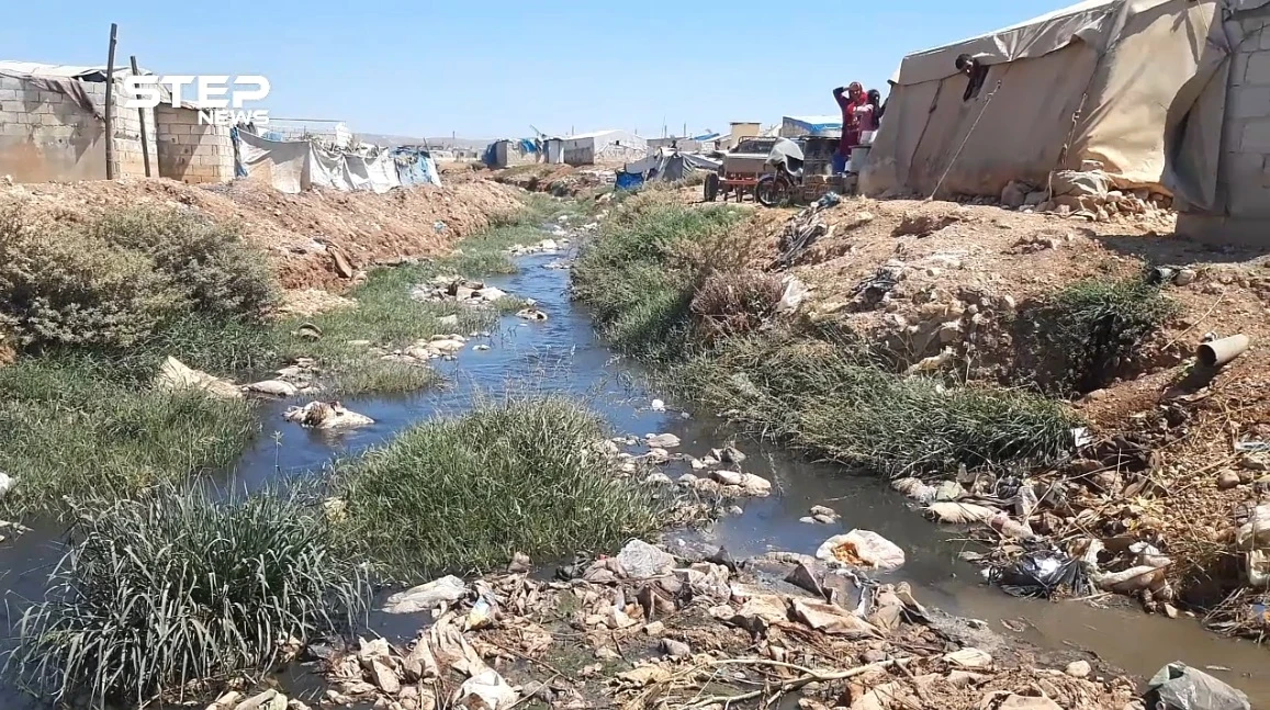 إضافة إلى ألم النزوح .. خيامهم على ضفاف قناة الصرف الصحي في أطمة بريف إدلب